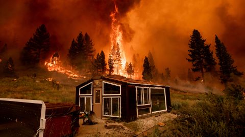 The Tamarack Fire burns behind a greenhouse in the Markleeville community of Alpine County, California, on Saturday, July 17, 2021. 