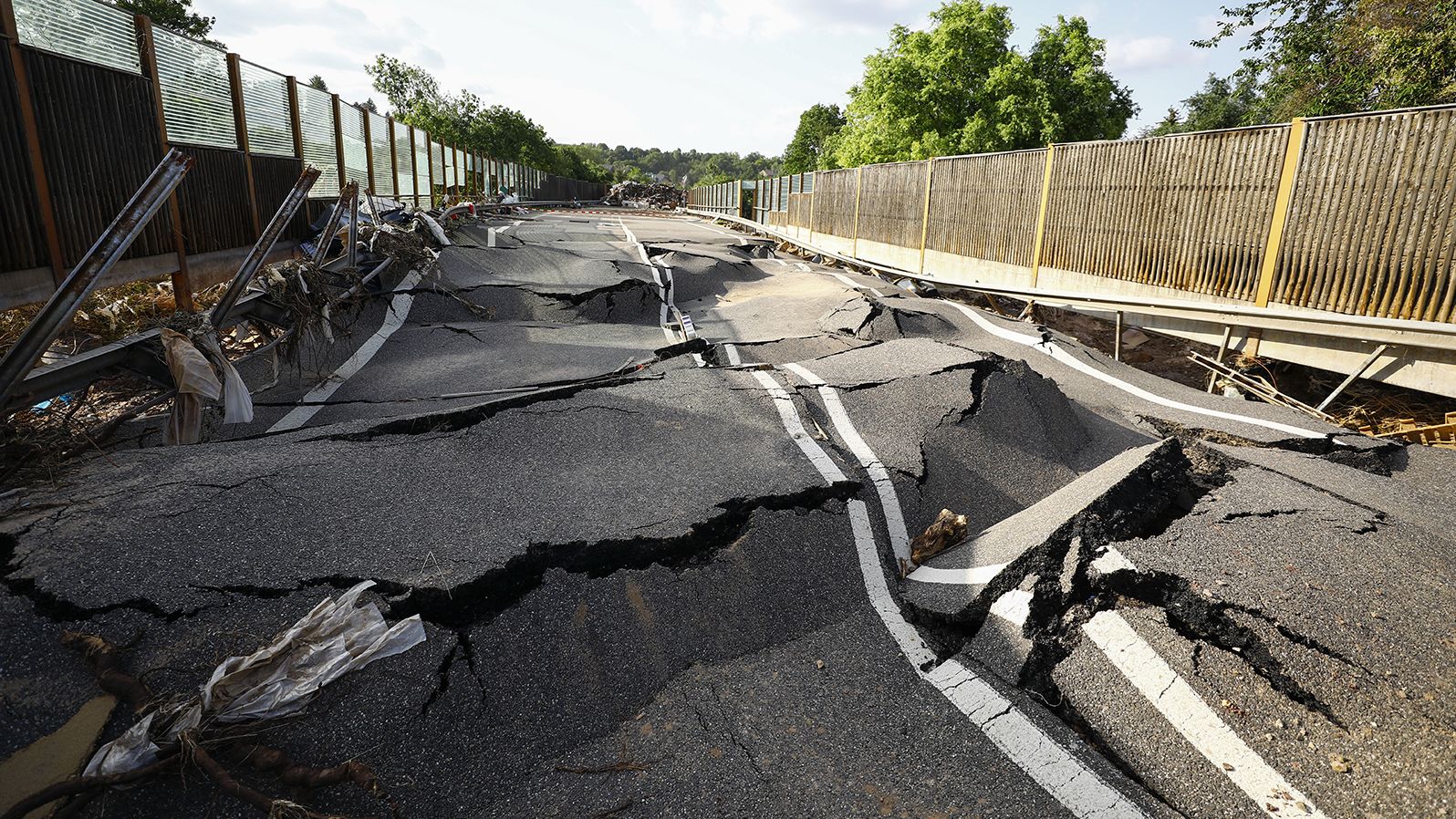 A damaged road buckles after flooding in Euskirchen, Germany.