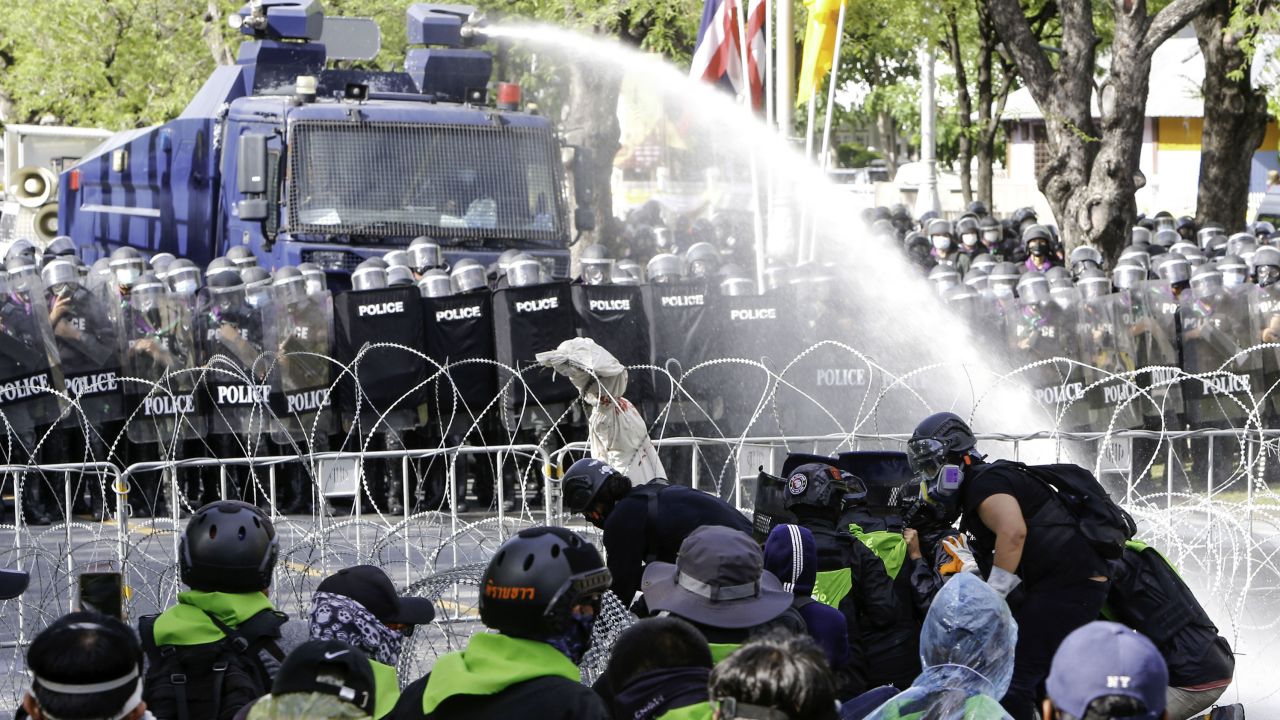 Police fire water cannon at protesters demanding the government be held accountable for its handling of the Covid-19 pandemic.