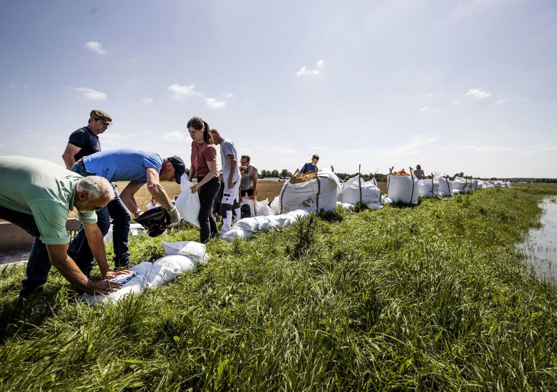 People build flood defenses using sandbags following heavy rains and floods in the Limburg province of the Netherlands.