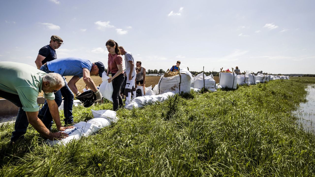 People build flood defenses using sandbags following heavy rains and floods in the Limburg province of the Netherlands.