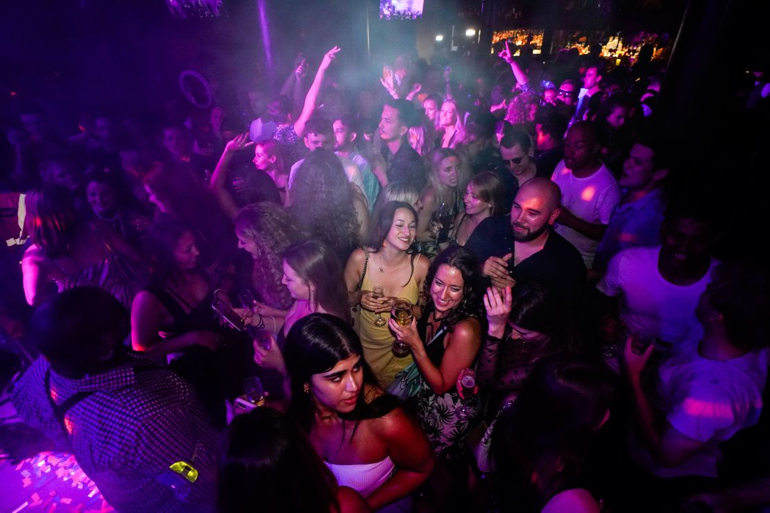 People hit the dance floor at The Piano Works in London early Monday.