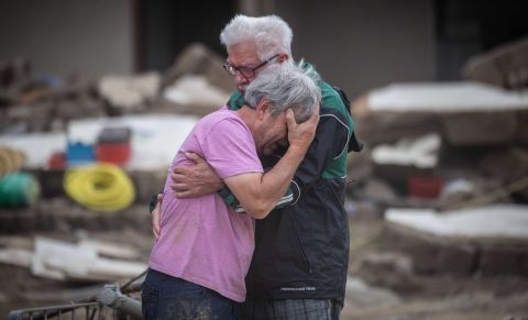 Two brothers embrace Monday, July 19, in front of their parents' home, which was destroyed by flooding in Altenahr, Germany.