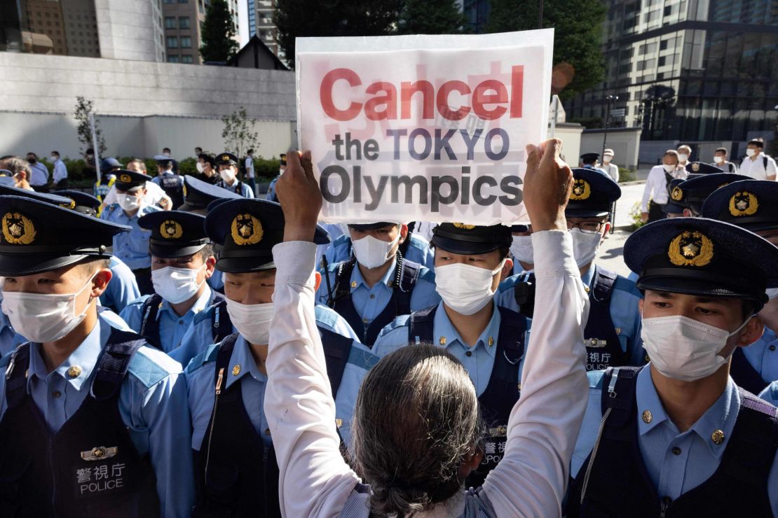 A photograph dated July 17, 2021, shows police officers blocking activists in Tokyo at a protest calling for the cancellation of the 2020 Olympic Games.