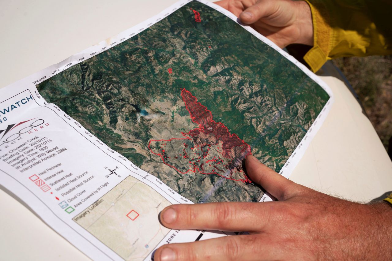 A member of the Northwest Incident Management Team 12 holds a map of the Chuweah Creek Fire as wildfires devastated Nespelem, Washington, on July 16.