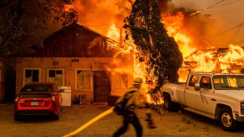 Fire consumes a home as the Sugar Fire, part of the Beckwourth Complex Fire, tears through Doyle, California, on July 10. It's the <a href=