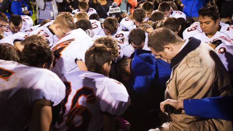 In this Oct. 16, 2015, file photo, Bremerton High School assistant football coach Joe Kennedy, center in blue, kneels and prays after his team lost to Centralia in Bremerton, Wash. (Lindsey Wasso/The Seattle Times via AP, File)