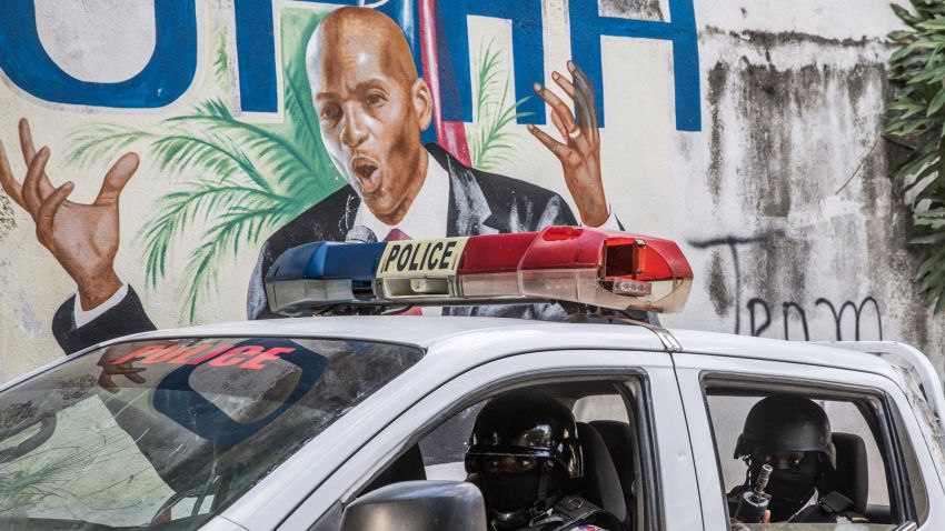 A police convoy drives past a wall painted with the president's image down the alley of the entrance to the residence of the president in Port-au-Prince on July 15, 2021, in the wake of Haitian President Jovenel Moise's assassination on July 7, 2021. - The assassination of Jovenel Moise by armed mercenaries was planned in the neighboring Dominican Republic, say Haitian police, who announced the detention of the slain president's chief bodyguard and three other members of his security detail. (Photo by Valerie Baeriswyl / AFP) (Photo by VALERIE BAERISWYL/AFP via Getty Images)
