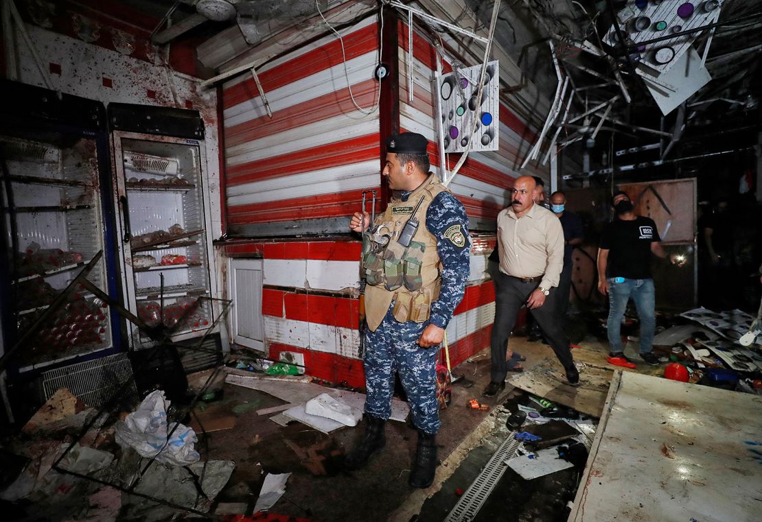 Iraqis inspect the site of an explosion at a popular market in eastern Baghdad on July 19.