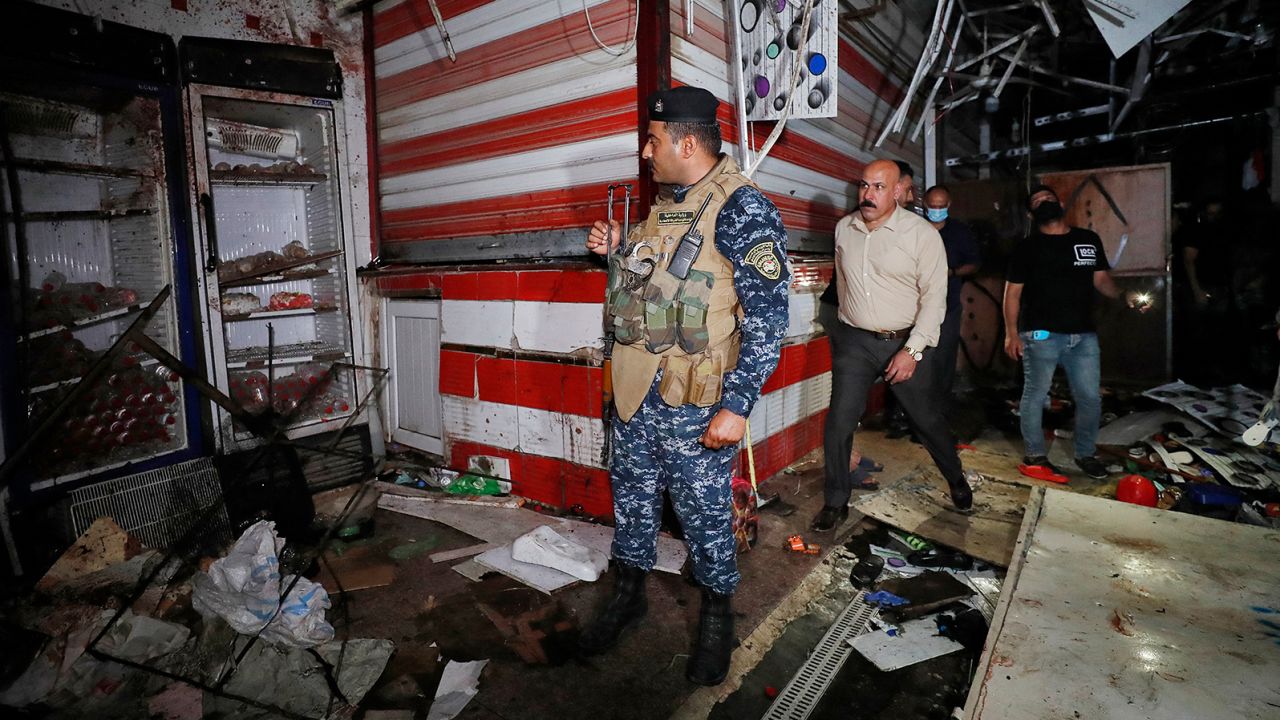 Iraqis inspect the site of an explosion at a popular market in eastern Baghdad on July 19.