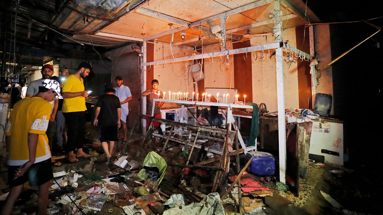 Iraqis light candles at the site of the explosion in a popular market in the mostly Shiite neighbourhood of Sadr City, east of Baghdad, on July 19, 2021.
