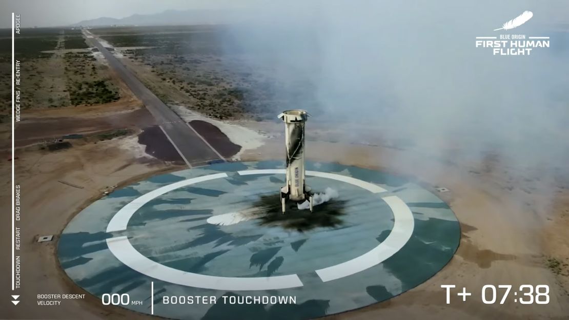 The New Shepard rocket booster rests on the ground after launching the capsule into space.