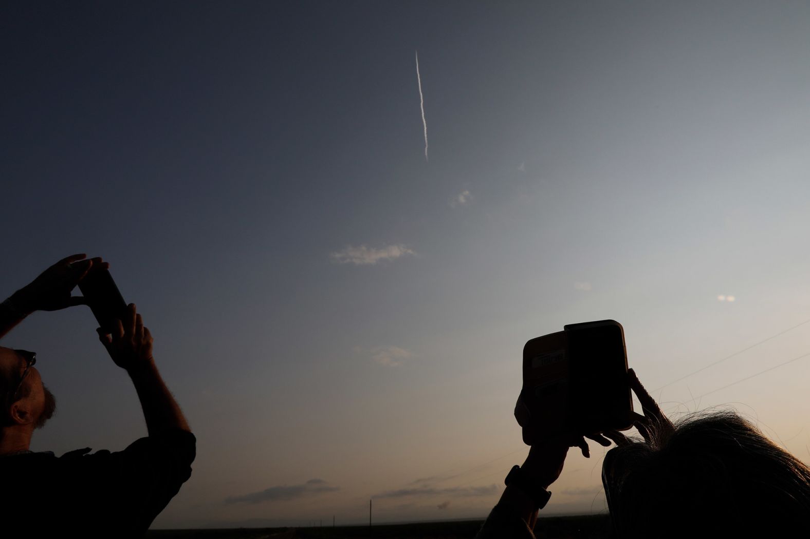 Spectators take pictures of the launch.