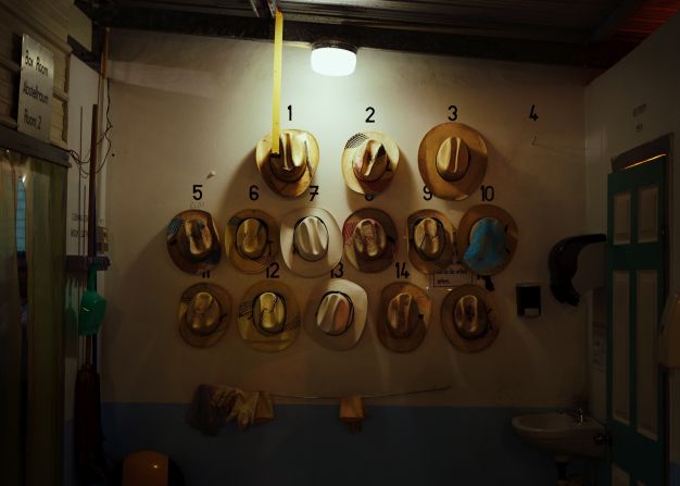 Mennonite men's hats pictured hanging up at a papaya-packing factory.