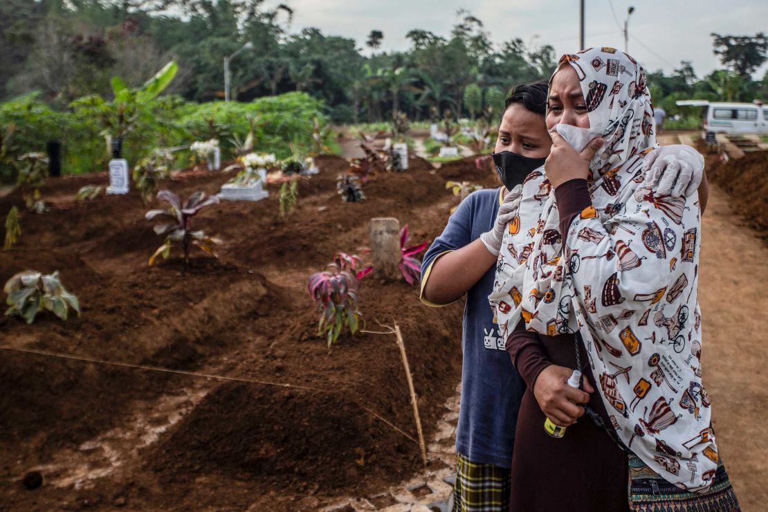 A woman mourns with her son during her mother's funeral at the Mulyaharja cemetery for Covid-19 victims, in Bogor, West Java, Indonesia on July 8, 2021. 