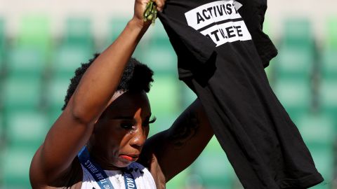 Gwen Berry holds up a shirt reading "Activist Athlete" as she celebrates finishing third in the Women's Hammer Throw final on day nine of the 2020 US Olympic Track & Field Team Trials on June 26, 2021.