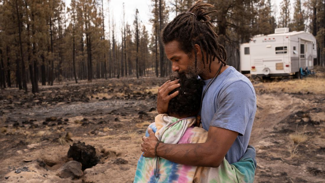 Nicolas Bey, 11, hugs his father, Sayyid, near a donated trailer they are using after their home was burned in the Bootleg Fire near Beatty, Oregon.