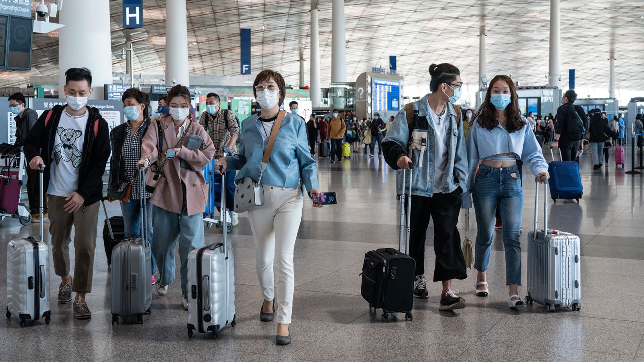 Travelers walk through Beijing Capital International Airport in Beijing, China, on Saturday, May 1, 2021.