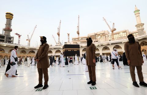 Saudi police officers stand guard as people walk around the Kaaba on Tuesday.