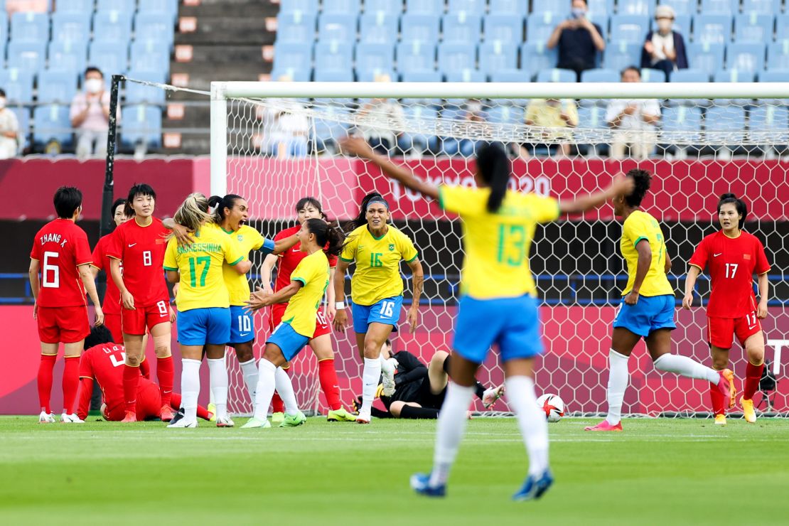 Marta celebrates with teammates after scoring her team's first goal against China. 