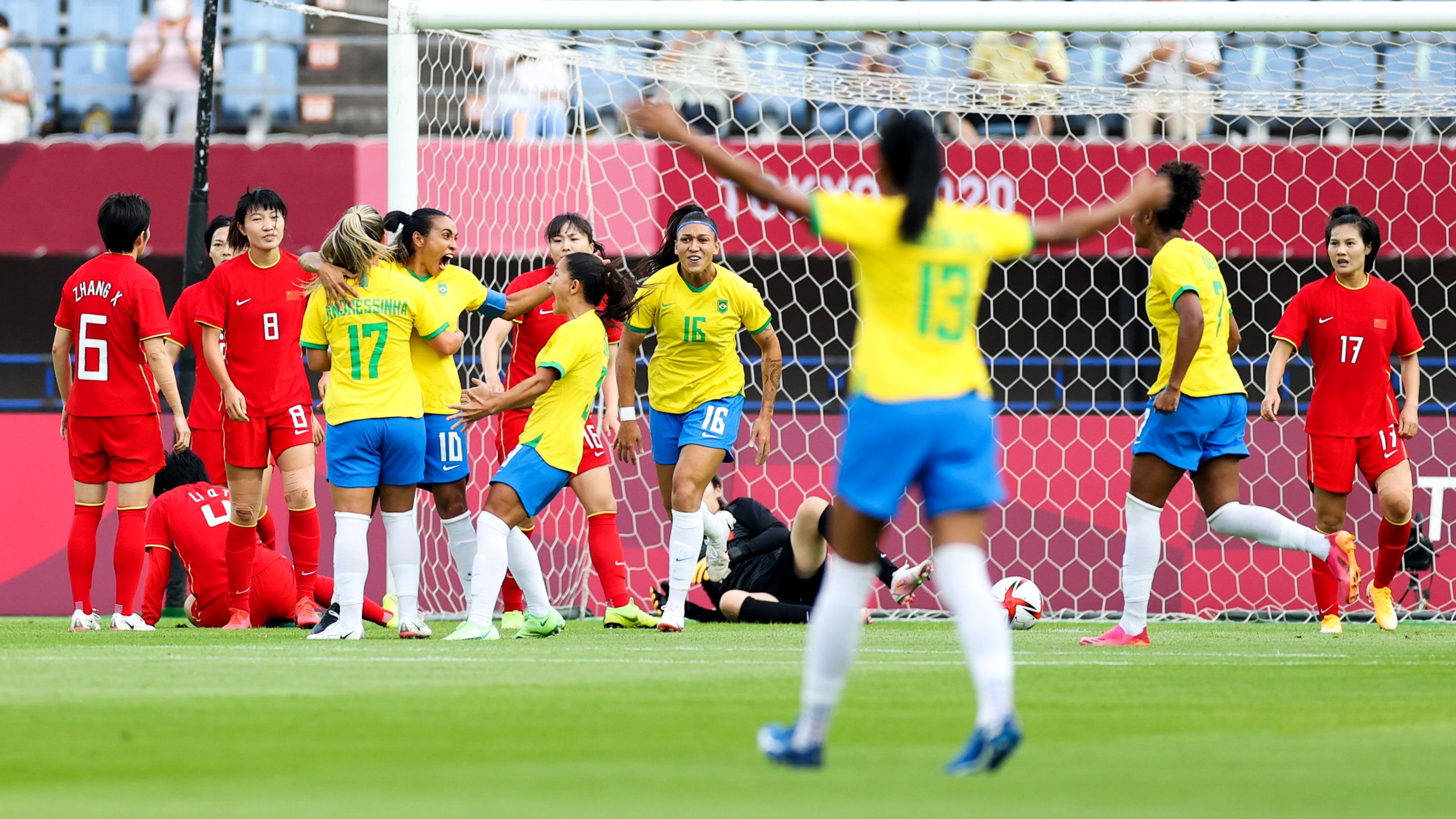 Marta celebrates with teammates after scoring her team's first goal against China. 