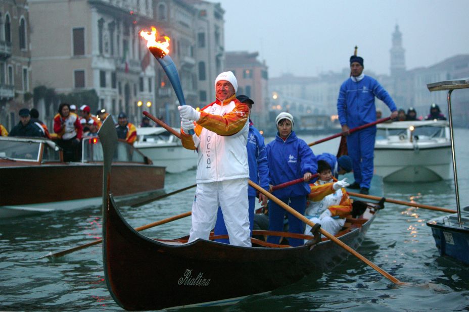 An Italian torchbearer holds the Olympic flame in a gondola on Canale Grande in Venice in 2006 on the way to the Turin Winter Games.
