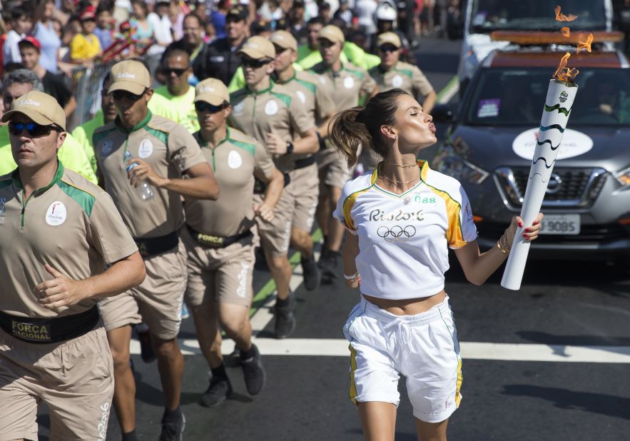 Model Alessandra Ambrosio runs with the Olympic flame through Rio de Janeiro for the 2016 Summer Games.