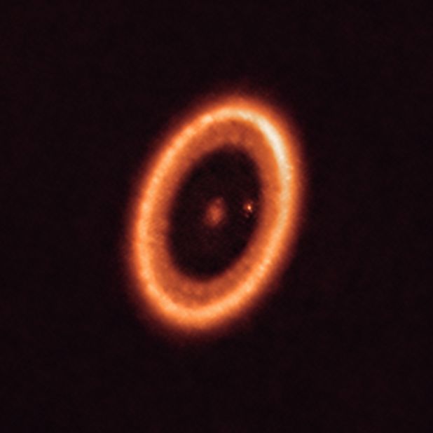 This image, taken with the Atacama Large Millimeter/submillimeter Array in Chile, shows the PDS 70 system 400 light-years away. This planetary system is still forming and still in the process of being formed. One of the planets in the system has a moon-forming disk around it.