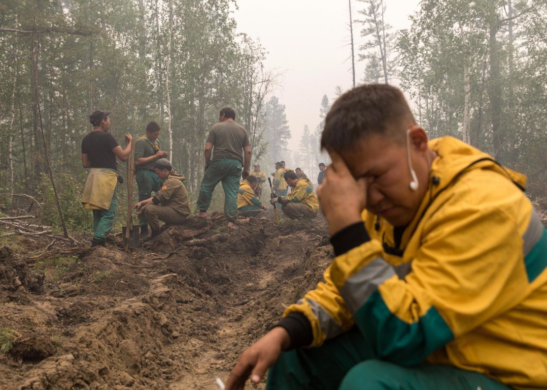 Employees of the forest protection service Yakutlesresurs rest as they dig a firebreak moat to stop a fire outside Magaras village in Yakutia.