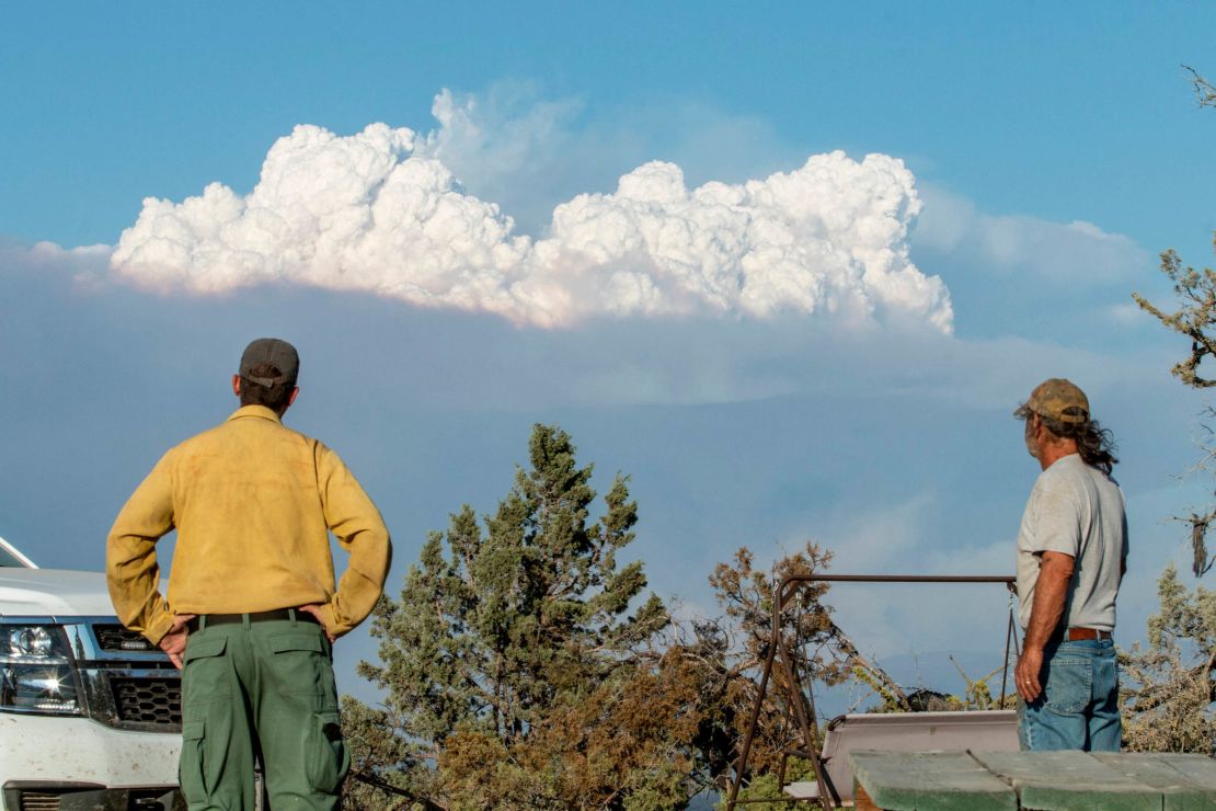 Fire Mitigation and Education Specialist Ryan Berlin (L) and Bob Dillon watch the Bootleg Fire smoke cloud from Dillon's home in Beatty, Oregon, on July 16, 2021.