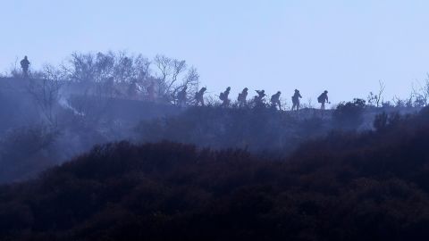 Firefighters walk near a wildfire in Topanga, California, on July 19.