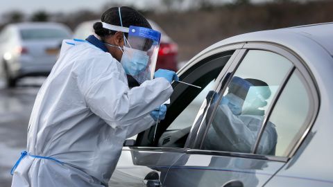 Nurse practitioner Deborah Beauplan administers a COVID-19 swab test at a drive-thru testing site set up for Suffolk County employees and their families at Smith Point Park in Shirley, New York on December 19, 2020.