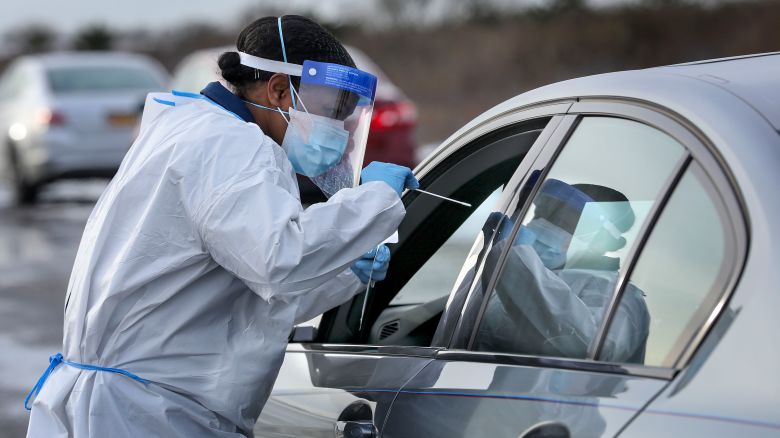 Nurse practitioner Deborah Beauplan administers a COVID-19 swab test at a drive-thru testing site set up for Suffolk County employees and their families at Smith Point Park in Shirley, New York on December 19, 2020.