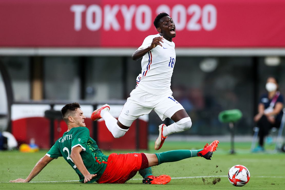 Montes Cesar of Mexico competes for the ball with Kolo Muani Randal of France.