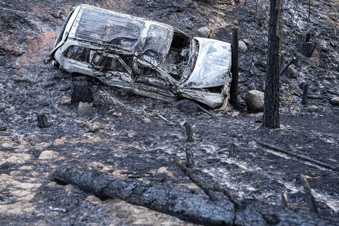 A burned car damaged by the Bootleg Fire is seen here along a mountain road on Wednesday, July 21, 2021 near Bly, Ore. (AP Photo/Nathan Howard)