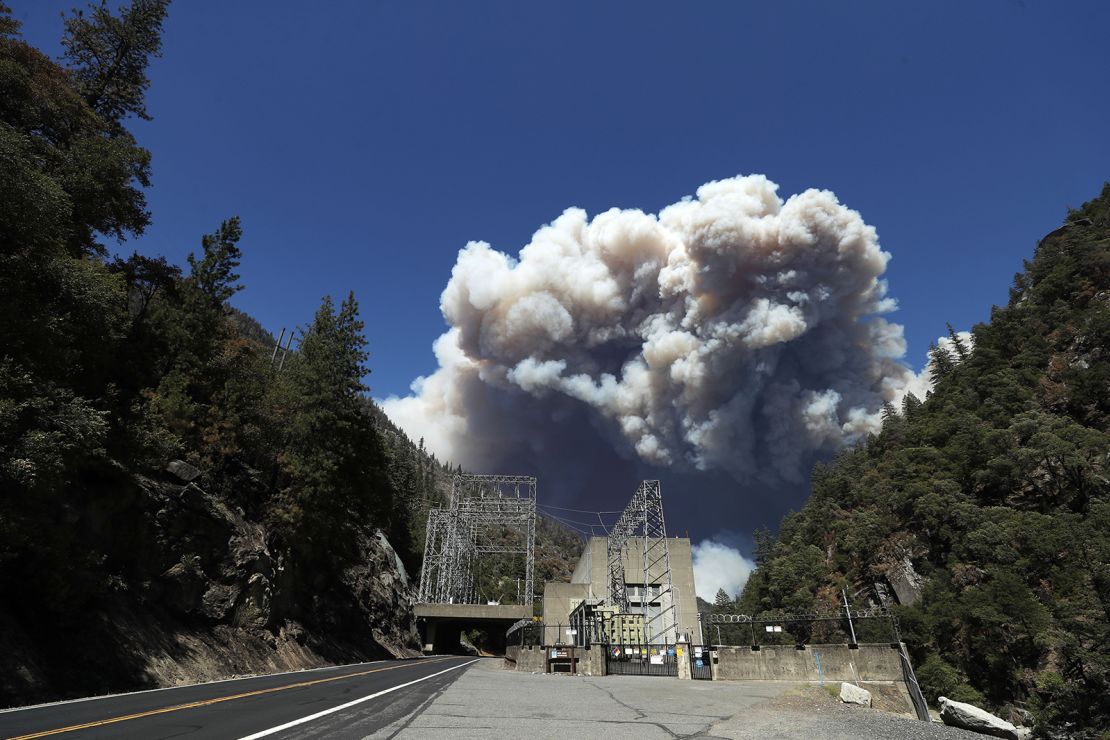 Heavy smoke billows  from the Dixie fire above the Plumas National Forest near the Pacific Gas and Electric  Rock Creek Powerhouse in Belden, California.