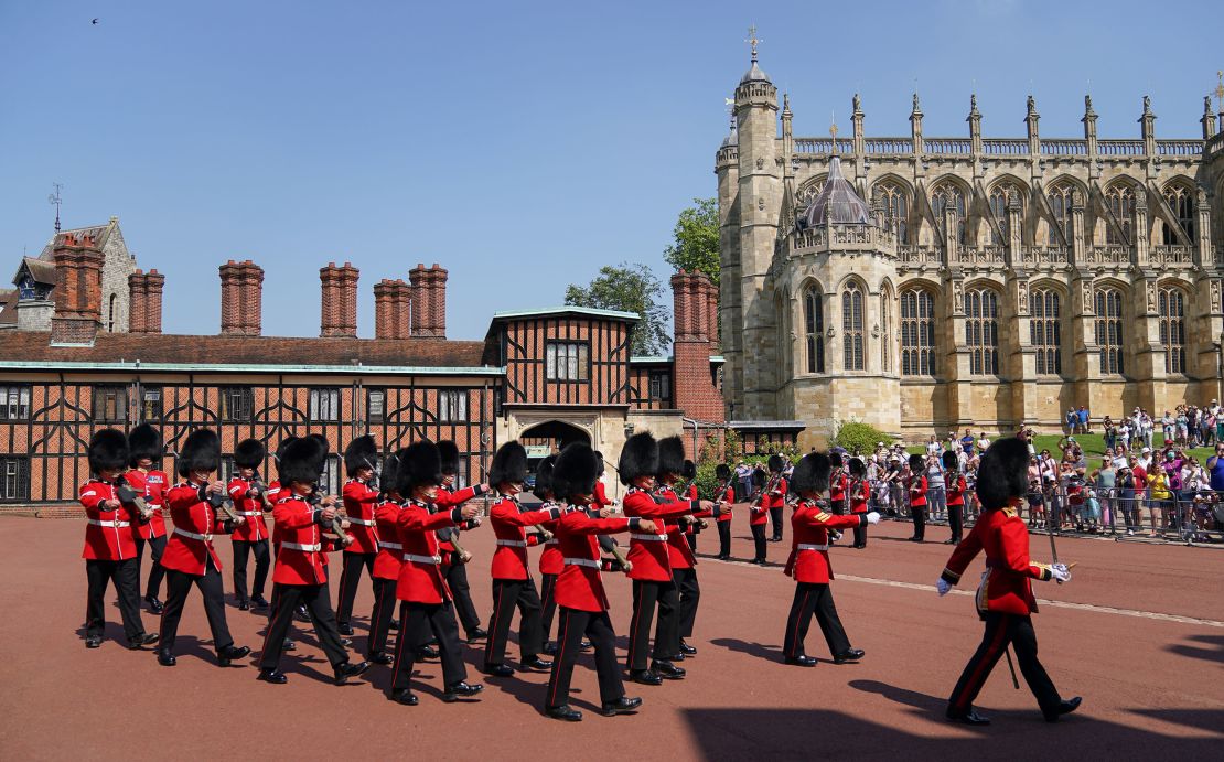 Members of the 1st Battalion Grenadier Guards march out of Windsor Castle in Berkshire after taking part in the Changing of the Guard for the first time since the start of the coronavirus pandemic.