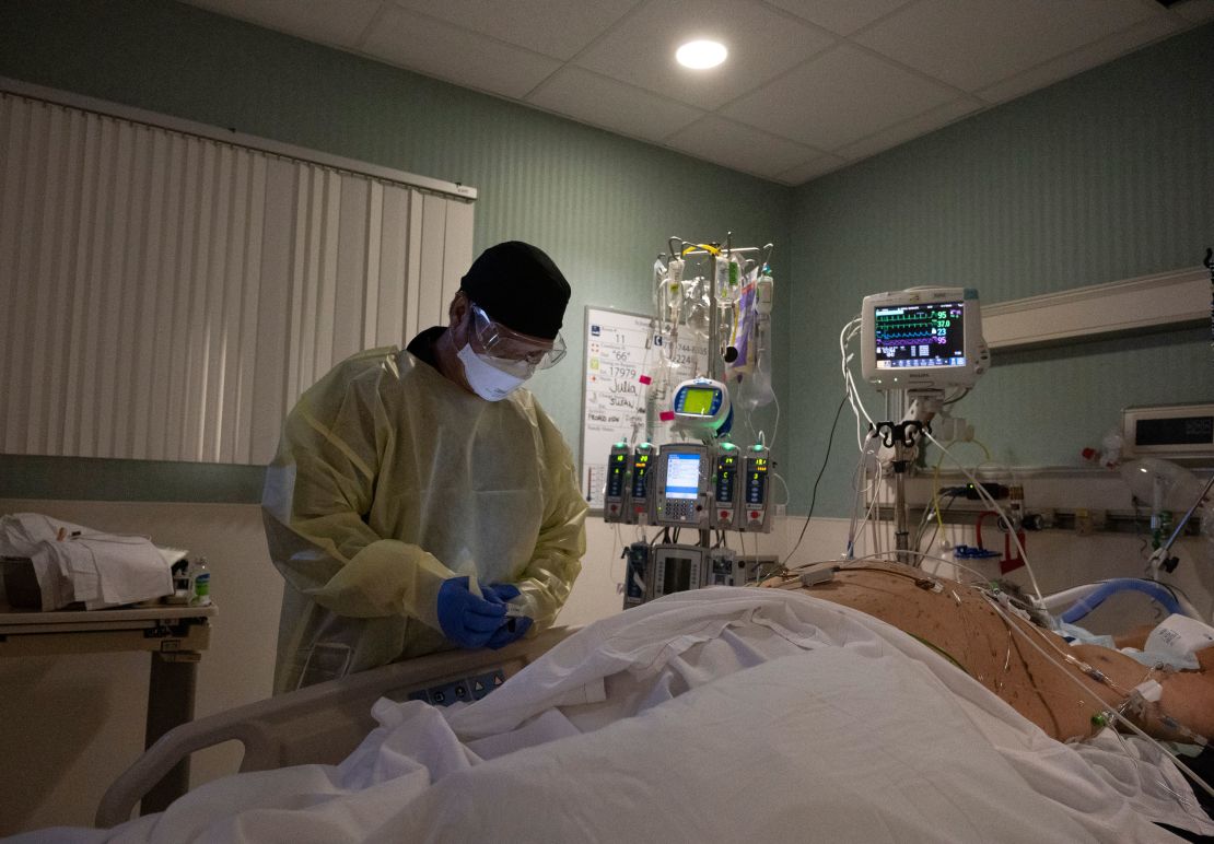 Nurse Leo Yrad checks the blood sugar of a Covid-19 patient at St. Joseph Hospital in Orange, California.