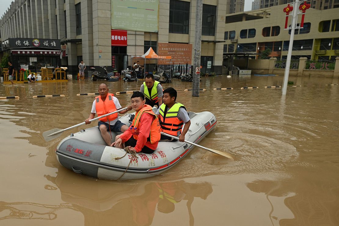 Rescue workers paddle through a flooded street in Zhengzhou, China, on July 23.