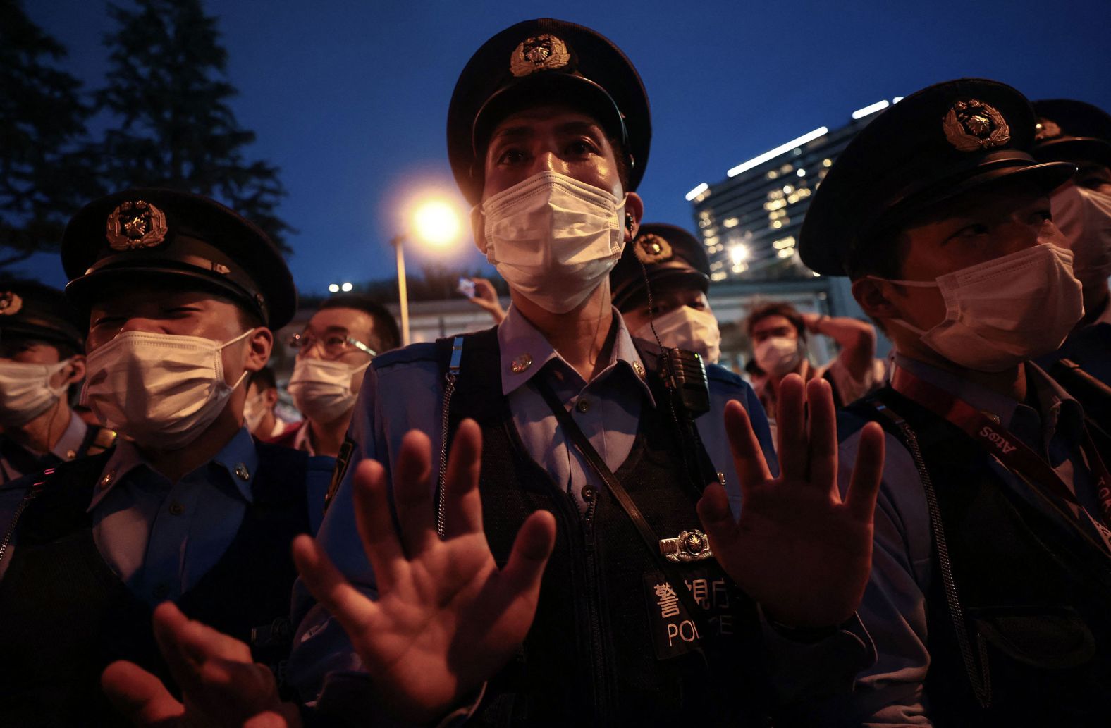 A police officer gestures toward a small group of people who were protesting the Olympics outside the stadium on July 23. A significant portion of the Japanese public <a href="index.php?page=&url=https%3A%2F%2Fwww.cnn.com%2F2021%2F07%2F22%2Fsport%2Ftokyo-olympics-preview-spt-intl%2Findex.html" target="_blank">opposes holding the Olympics in the middle of a pandemic.</a>