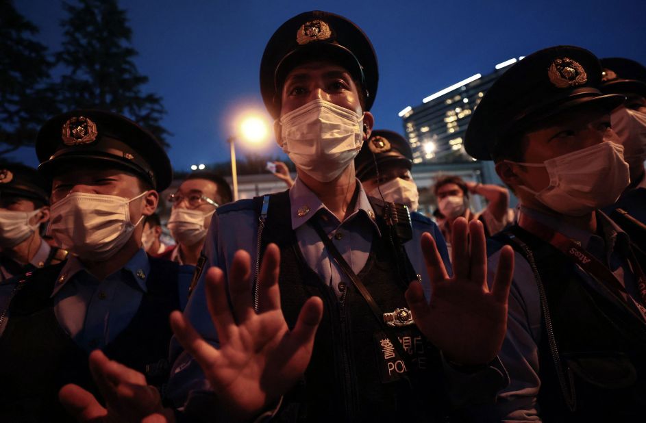 A police officer gestures toward a small group of people who were protesting the Olympics outside the stadium on July 23. A significant portion of the Japanese public <a href="https://www.cnn.com/2021/07/22/sport/tokyo-olympics-preview-spt-intl/index.html" target="_blank">opposes holding the Olympics in the middle of a pandemic.</a>