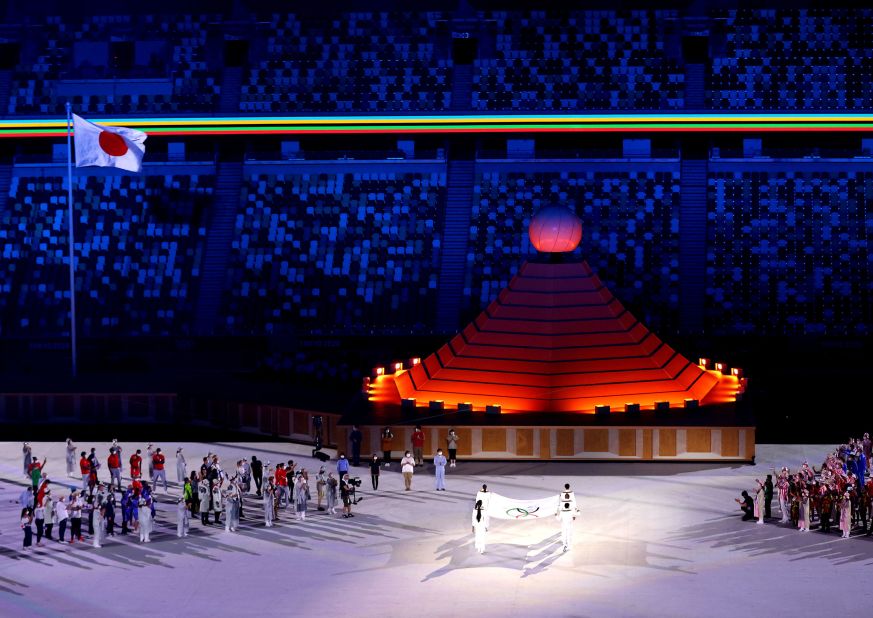 The Olympic flag is carried toward the Olympic cauldron during the opening ceremony.
