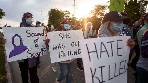 Young women march with signs during a Multi-Faith March to End Hatred after four members of a Muslim family were killed in a truck ramming attack in Canada.