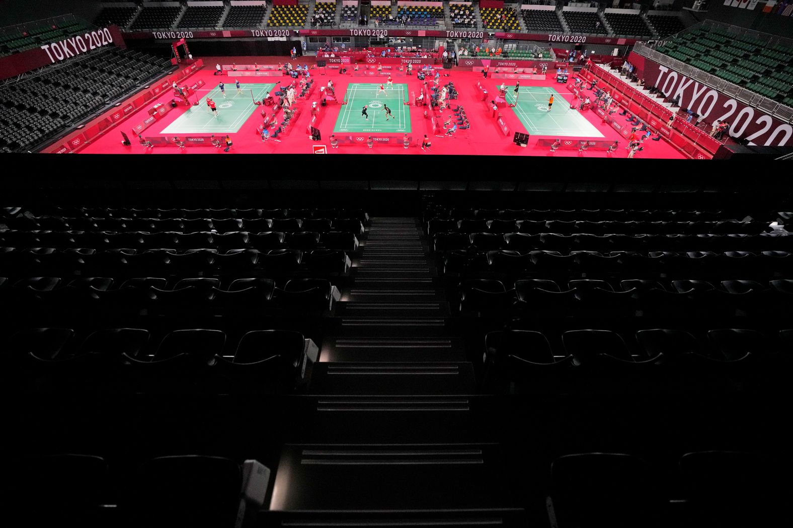 Badminton players compete amid rows of empty seats on July 24.