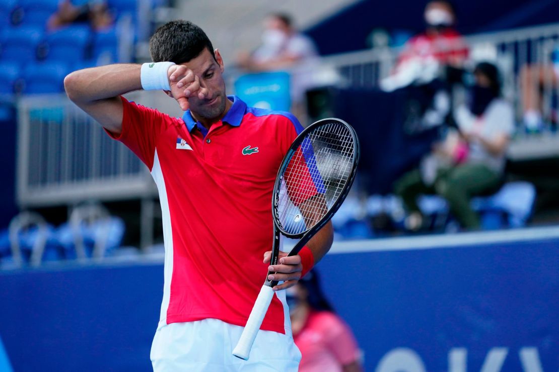 Novak Djokovic wipes sweat from his brow during his match against Bolivia's Hugo Dellien.