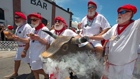 Ernest Hemingway look-alikes push a fake bull with smoke emanating from its nostrils during the "Running of the Bulls" Saturday in Key West, Florida.
