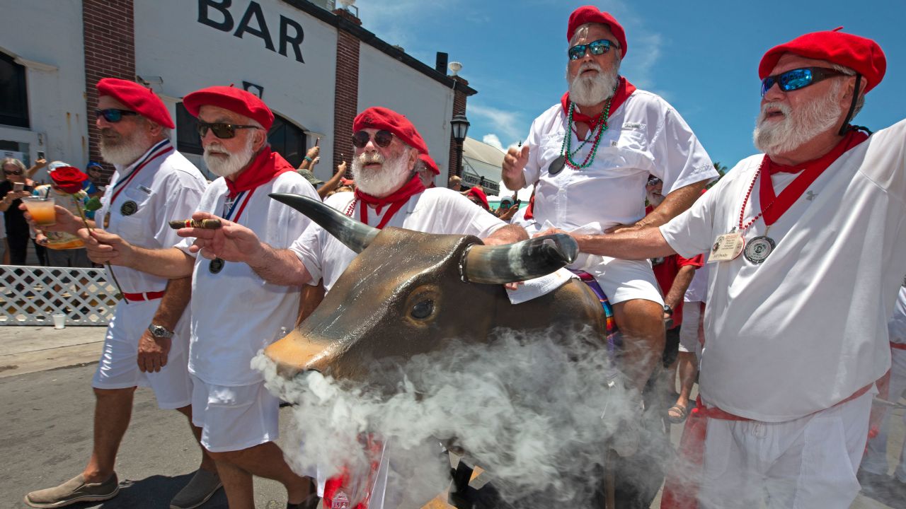 Ernest Hemingway look-alikes push a fake bull with smoke emanating from its nostrils during the "Running of the Bulls" Saturday in Key West, Florida.