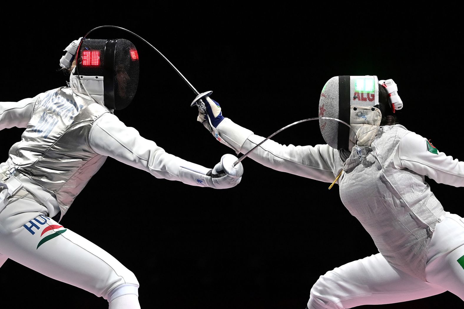 Hungarian fencer Flora Pasztor, left, competes against Algeria's Meriem Mebarki on July 25.