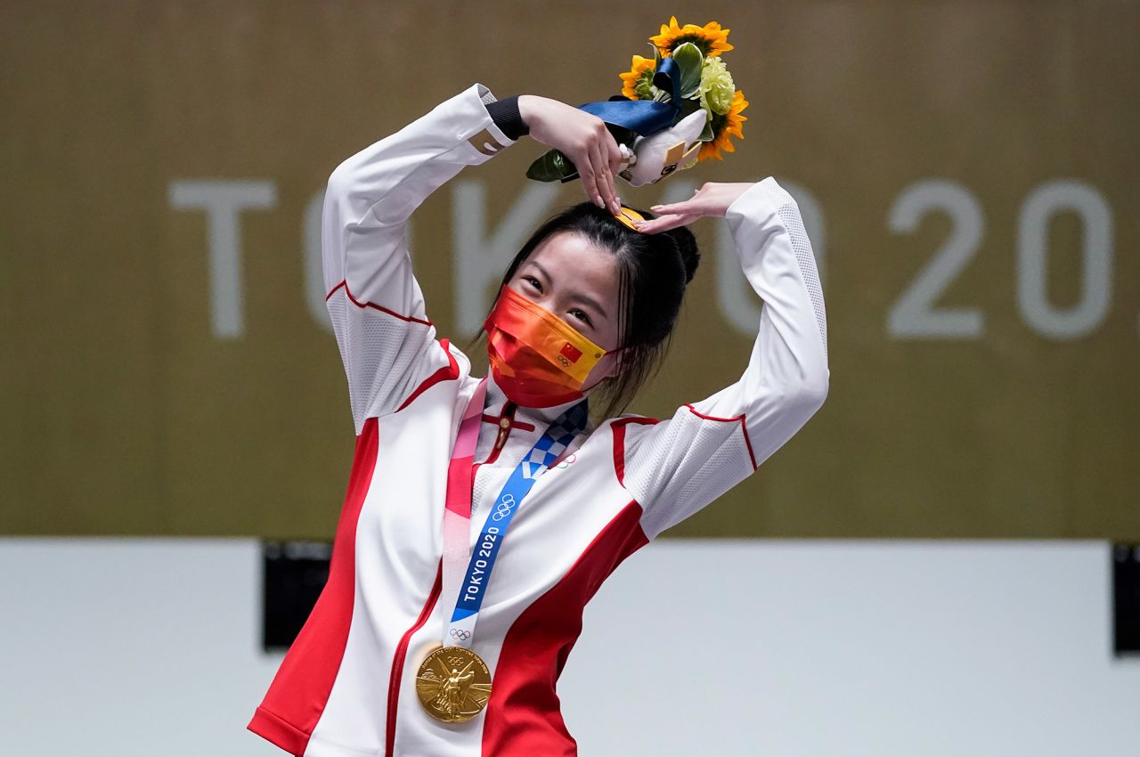 China's Yang Qian, the first gold-medal winner of these Olympics, celebrates on July 24. She finished first in the 10-meter air rifle.