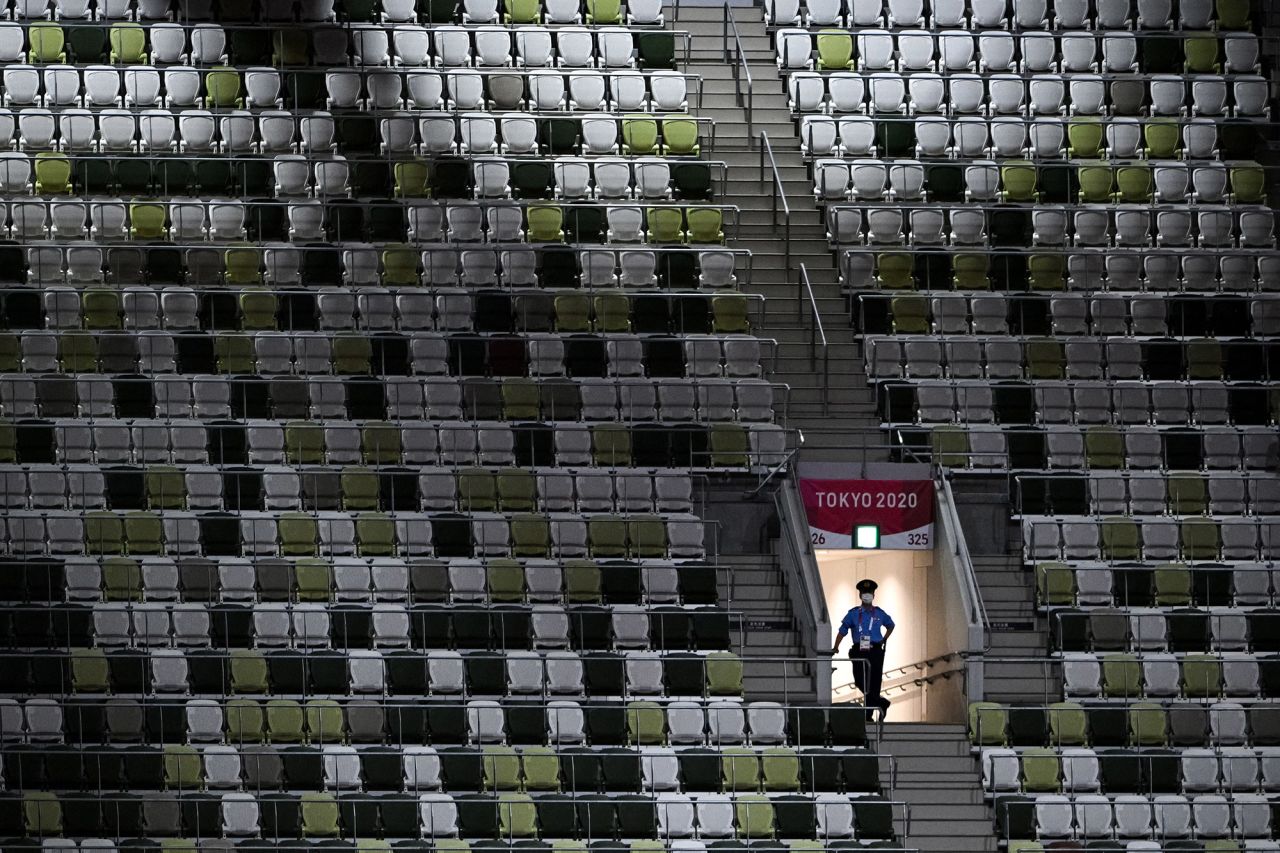 A police officer is seen in the mostly empty stadium on July 23. Organizers said that for the opening ceremony, only 950 VIPs would be present in a stadium that can seat nearly 70,000 people.